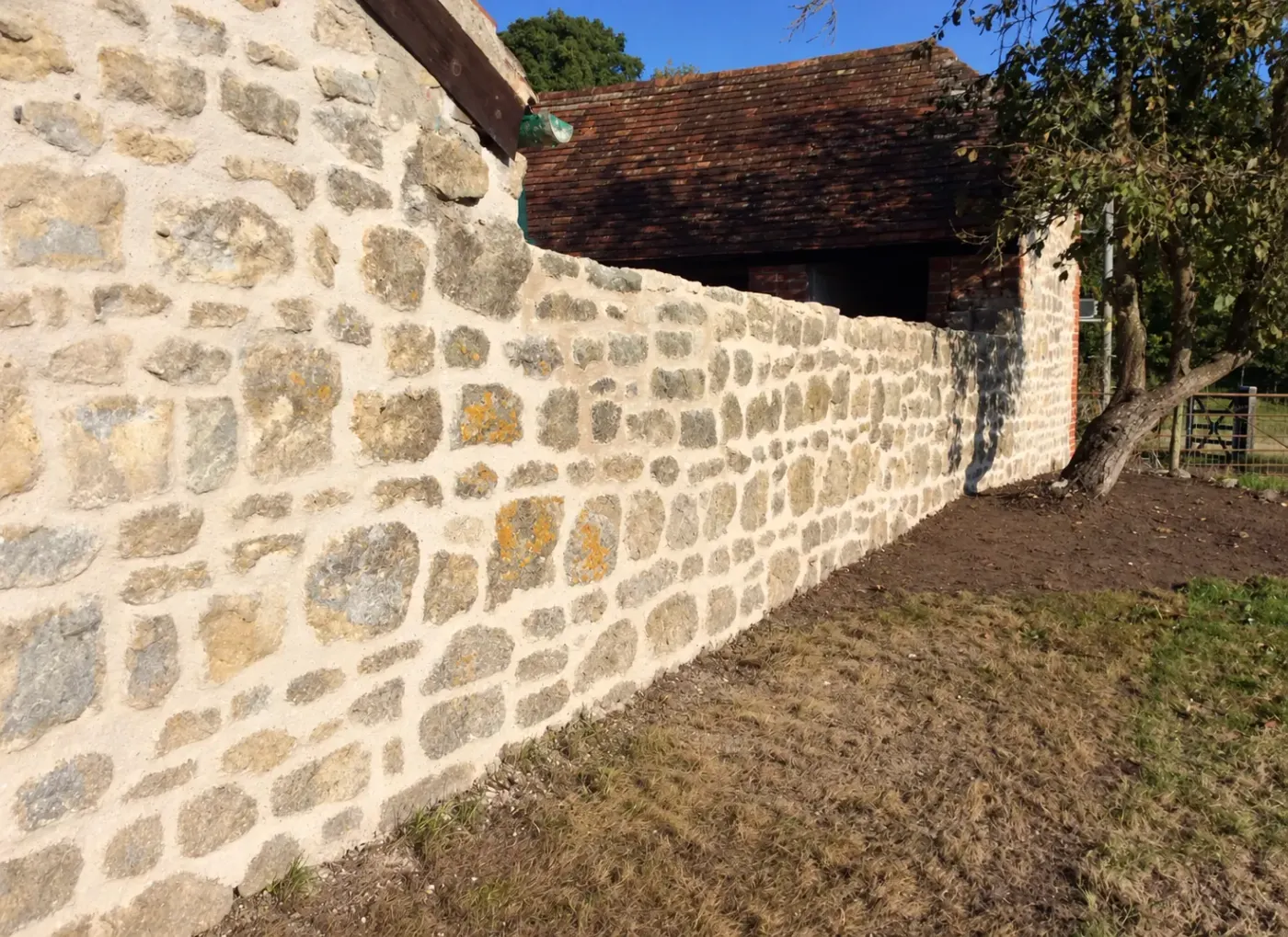 Mur en pierre après rejointoiement, joints refaits à finition naturelle